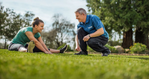 Man coaching a woman while stretching